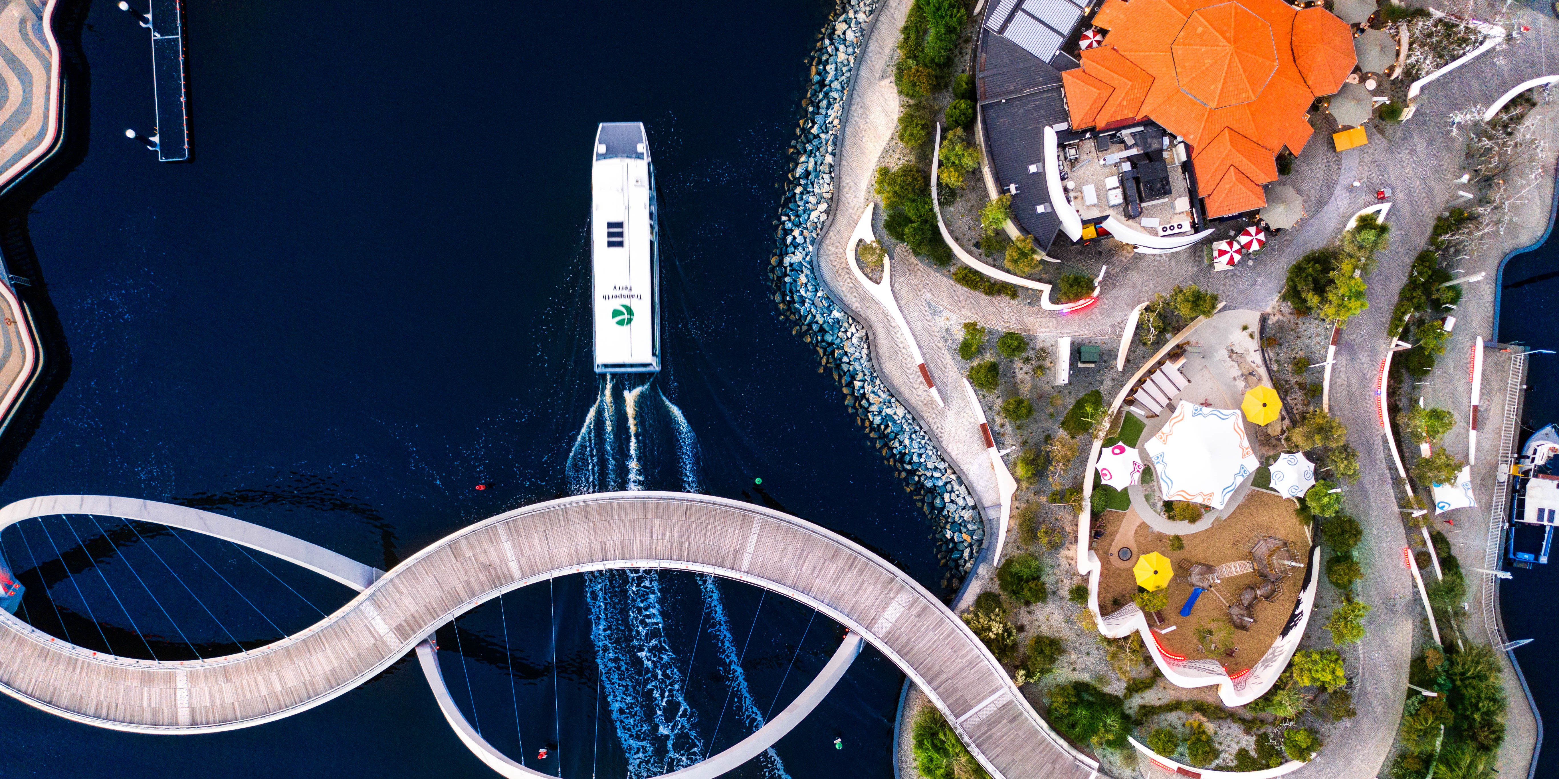 Top view of a ferry going under a bridge