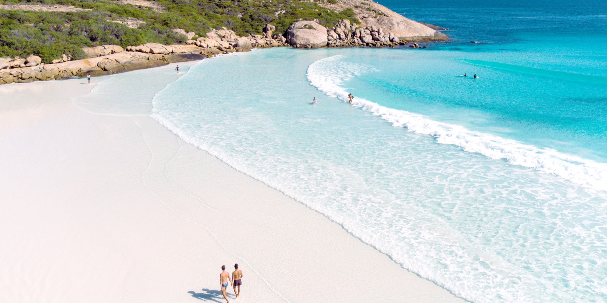 Two people walking on the beach